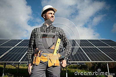 Expert is inspecting quality of a solar batterys. Worker in uniform and helmet with equipment. Ecology power Stock Photo