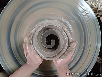 The expert is sculpting the clay into the desired shape. Is one of the process of making pottery Stock Photo