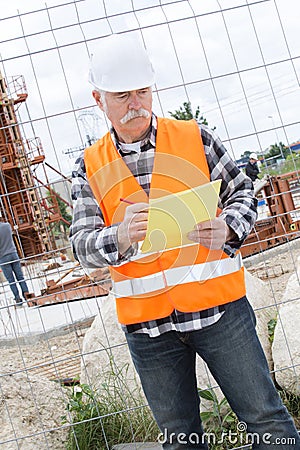 Expertise architect senior engineer plans construction outdoors Stock Photo