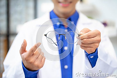 Expirienced doctor advising eyeglasses in ophthalmologic cabinet. optometrist giving new glasses Stock Photo