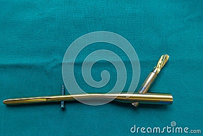 explanted titanium femur nail on a green surgical drape Stock Photo