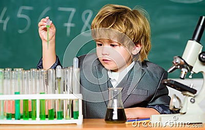 Explore biological molecules. Toddler genius baby. Boy near microscope and test tubes in school classroom. Technology Stock Photo