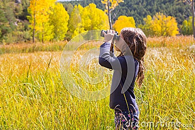 Explorer binocuar kid girl in yellow autumn nature Stock Photo