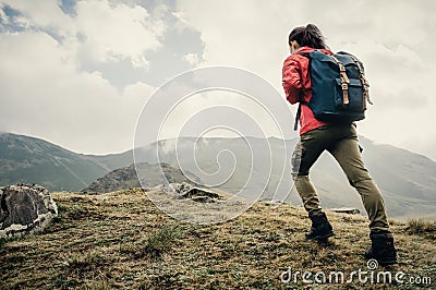 Explorer girl going up on mountain. Stock Photo