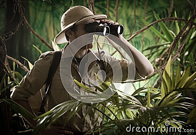 Explorer in the jungle with binoculars Stock Photo