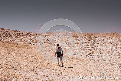 Exploring - lonely human walking in a rocky desert freedom and adventure lifestyle and sport concepts Stock Photo