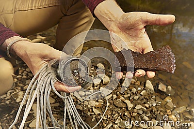 Exploring of river with magnet on rope and finding of axe Stock Photo