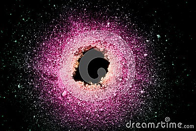 An explosion of pastel natural colored pigment powder on black background. Purple green yellow particles textured background Stock Photo