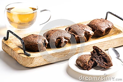 Exposition of very tasty chocolate cake with soft inside in wooden plate on white background,perfect desert with tea. Stock Photo