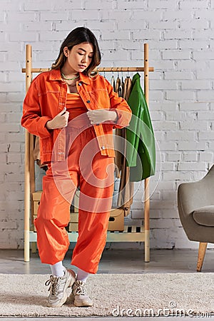 expressive asian stylist in trendy orange Stock Photo