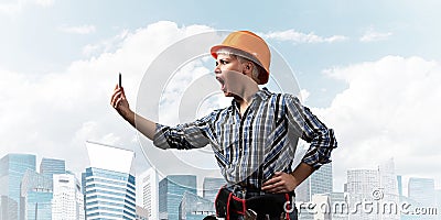 Expressive blonde woman in workwear and hardhat Stock Photo