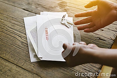 View of Angry Hands with an Overdue Notice and Keys - Expressive - Letter - Hardship - Bills Stock Photo