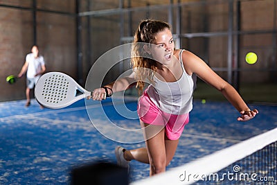 Expressive resolved girl playing paddle ball on closed court Stock Photo