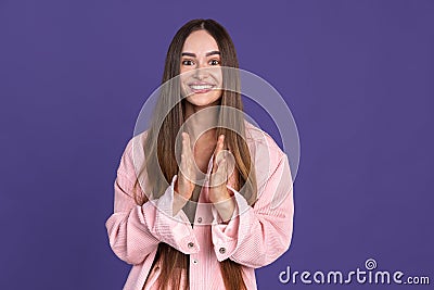 Expressive smile. Cropped portrait of young beautiful woman gesturing on purple background Stock Photo