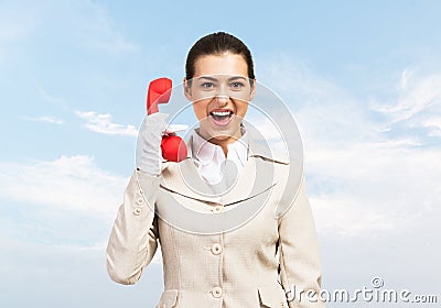 Expressive woman holds handset phone on distance Stock Photo