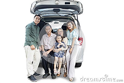 Extended Asian family sitting in the car trunk Stock Photo