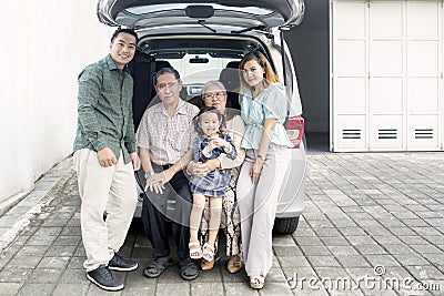 Asian family sitting on the car trunk Stock Photo