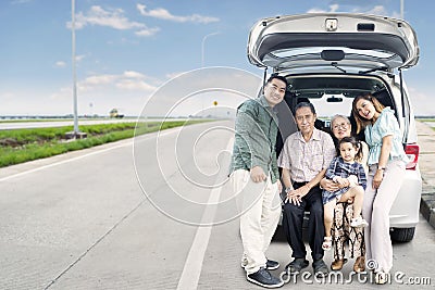 Extended happy family sitting on the car trunk Stock Photo