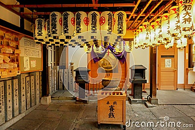 Extensive interior of Japanese shrine with decorate paper lanterns, donation box and iron incense pot Editorial Stock Photo