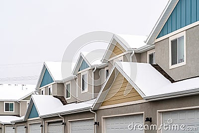 Exterior of apartments with gable roofs and dormers covered with snow in winter Stock Photo