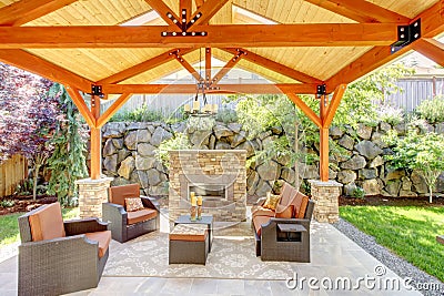 Exterior covered patio with fireplace and furniture. Stock Photo