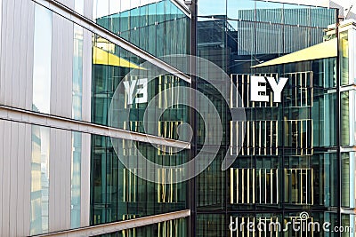 Exterior of EY office in London with visible logo reflected in glass Editorial Stock Photo