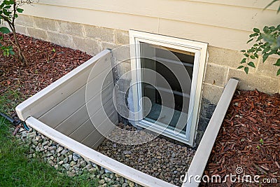 Exterior view of an egress window in a basement bedroom. These windows are required as part of the USA fire code for basement Stock Photo