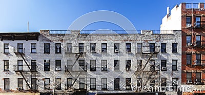Exterior view of the facade of an old brick apartment buildings with windows and fire escapes in New York City Stock Photo