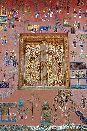 Exterior wall with beautiful mosaic and gold painted window of the pavilion at Xieng Thong temple in Luang Prabang, Laos. Stock Photo