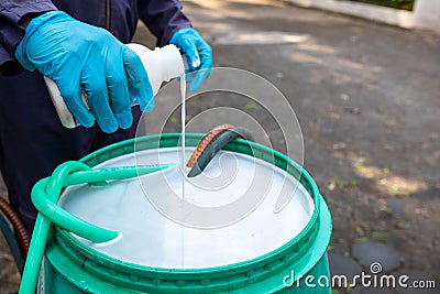 exterminate termite control company employee is using termite sprayer at customer's house and searching for termite nests to Stock Photo