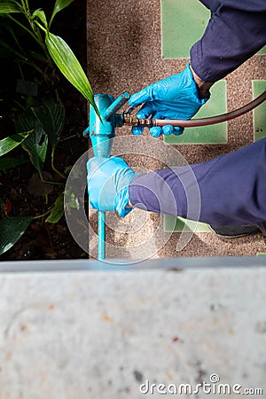 exterminate termite control company employee is using a termite sprayer at customer house and searching for termite nests to Stock Photo