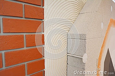 External brick wall insulation. House brick wall insualtion with glue plastering layers, reinforcment mesh, aerated concrete Stock Photo