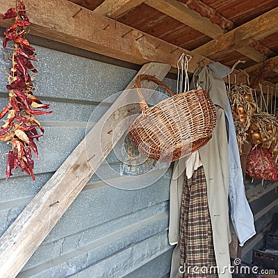 External storage room, dried peppers, onions, a wicker basket and a coat Stock Photo