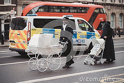 Extinction Rebellion activists marching next to Downing Street with White Baby Prams in front of Police officers Editorial Stock Photo