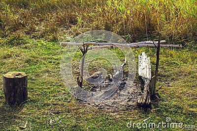 Extinguished bonfire in a field in a green meadow Stock Photo