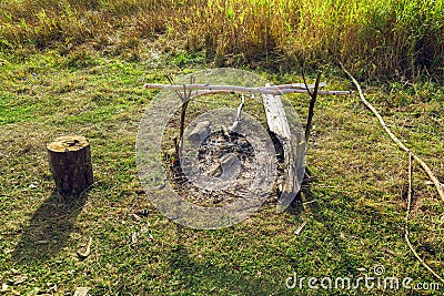 Extinguished bonfire in a field in a green meadow Stock Photo