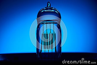 Extinguished electric vintage Edison light bulb with a spiral on a blue background. Retro style lamp Stock Photo