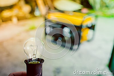 An extinguished light bulb on the background of a gas generator Stock Photo