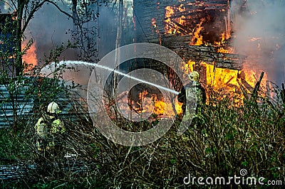 extinguishing the fire of a wooden house Stock Photo