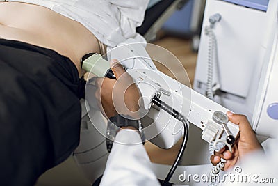 Extracorporeal shockwave therapy in urology. Cropped shot of belly of woman patient, having ultrasound to determine Stock Photo