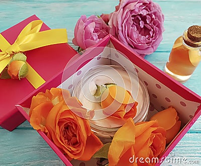 Extract, essence gift box cosmetic composition cream beautiful fresh orange rose on a blue wooden background Stock Photo