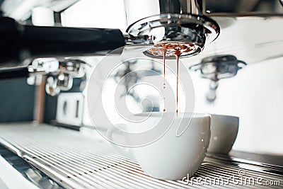 Extraction of espresso from bottomless portafilter in white cup Stock Photo