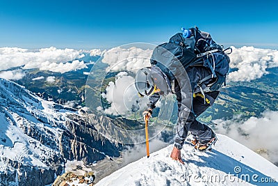 Extreme alpinist in high altitude on Aiguille de Bionnassay mountain summit, Mont Blanc massif, Alps, France, Europe Editorial Stock Photo