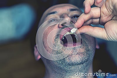 Extreme closeup man face taking white pill, mouth view swallowing pills, illness. man take medicine,open mouth and bring Stock Photo