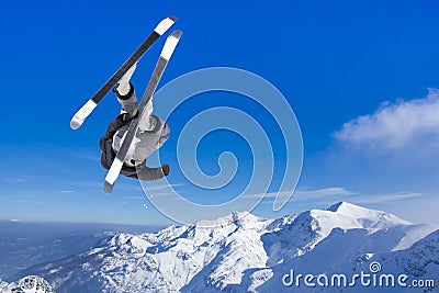 Extreme Jumping skier at jump above mountains Stock Photo