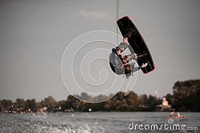 extreme man doing jump and somersault over splashing water on wakeboard Stock Photo