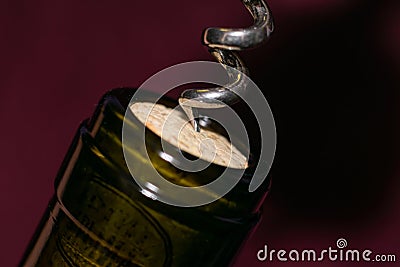 Extremely close up view of bottleneck of wine bottle and bottle-screw swirling cork Stock Photo