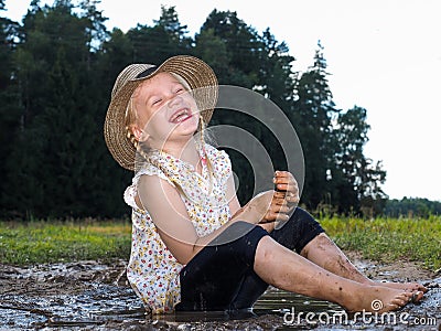 Extremely dirty baby laughing sitting Stock Photo