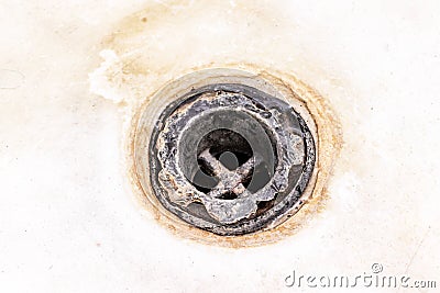 Extremely dirty bath drain mesh, hole covered with limescale or lime scale and rust close up, cleaning calcified and rusty Stock Photo