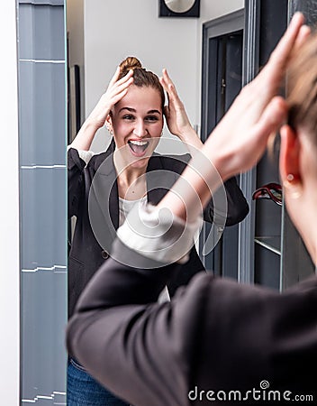 Extrovert young beautiful business woman enjoying looking at home mirror Stock Photo